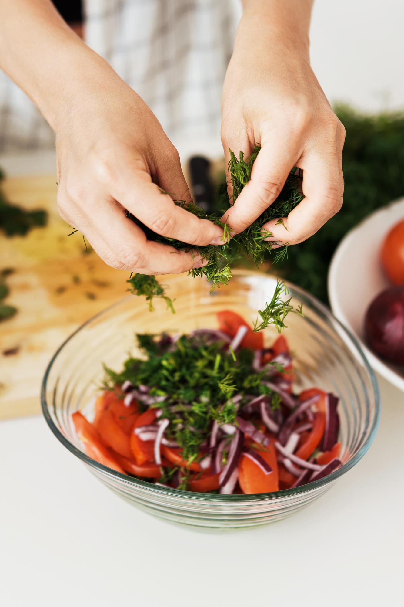 hands garnishing a salad